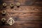 Gilded pine cones, metal stars and wood carved angel Christmas ornament on the dark brown plank wooden surface