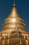 Gilded stupa on dark sky background.