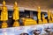 The gilden sculptures of Buddha in small Altar with burning oil lamps, San Lak Mueang shrine in Bangkok, Thailand