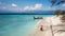 Gili Island - A couple standing on the white sand beach with a boat anchored to the shore behind them