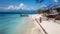 Gili Island - A couple standing on the white sand beach with a boat anchored to the shore behind them