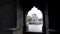 gimbal clip walking towards shish gumbad framed by an arch in delhi