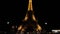 Gimbal shot Closing to Eiffel tower in Paris at night by the road. Warm glowing huge metal construction