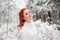 Ginger attractive female in white sweater in winter forest. Snow december in park. Portrait. Christmas cute time.