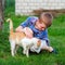 Ginger cat tenderly rubs against the foot of a little boy