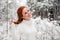 Ginger cute female in white sweater in winter forest. Snow december in park. Portrait. Christmas cute time.