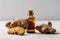 Ginger Essential Oil In Small Brown Bottle Next To Ginger On White Background. Generative AI