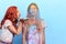 Ginger girl blowing colored powder to her friend`s face