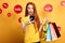 Ginger girl in stylish T-shirt holding shopping bags adn making a phone call