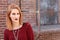 Ginger grungy woman and a brick wall. Fashion photo