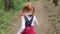 Ginger little girl running through the woods