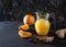 Ginger-orange juice in a glass pitchers, oranges, ginger and cinnamon on a black background. Fresh drink. Healthy eating