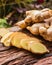 Ginger root - Fresh ginger root and sliced on old plank with nature background.