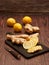 Ginger root, slices of ginger root and slices of lemon on a burned wood cutting board