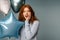 Ginger surprised woman looking at camera while posing with balloons