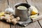 Ginger tea cup with lemon, ginger roots, garlic and knife on kitchen table