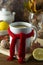 Ginger tea with honey and lemon. Tea cup with knitted red scarf. Autumn or winter warm drink. Wooden background