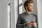 Ginger young man using mobile phone while leaning on wall