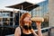 Ginger young woman with headphones drinking water after workout