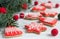 Gingerbread bells, stars, garland of felted beads and fir branches on a light background Christmas or New Year`s card.