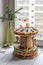 A gingerbread carousel and some Christmas decoration elements on a white wooden surface