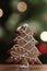 Gingerbread christmas tree against the background of bokeh of garlands of side flickering light bulbs