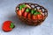 gingerbread in a glaze in the form of a pumpkin in a woven vase for Halloween on a gray background