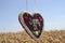 Gingerbread heart in front of a wheat field with the german bavarian text I like you