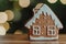 Gingerbread house against the background of bokeh of garlands of side flickering light bulbs