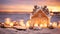 Gingerbread house, Christmas ornaments and candles on sandy beach against ocean background at sunset. Happy holidays and festive