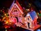 Gingerbread houses country with christmas lights string on wooden table.