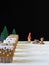 Gingerbread houses with a gnome, a moose and a sleigh with gifts. Black background for text