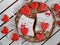 Gingerbread with a mural. Valentine`s Day. Cat with a heart and a bow on a white wooden background.