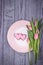 Gingerbread pink hearts and pink tulips on a wooden background. Top view, free space. Happy Valentine`s Day