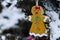 Gingerbread Woman Decoration on a Snowy Outdoor Christmas Tree