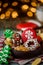 Gingerbreads in a brown wooden plate on a green wooden on the background of blurred garland. close up. space