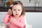 Girl 2 years old playing with a comb at home - portraying an emotional conversation on the phone.