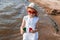 Girl of 3 years in white dress in red glasses, hat and wooden heart with colors of italy flag on beach summer, selective