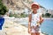 Girl 6-7 years old on Postiguet beach, looking at camera. Santa Barbara castle fortification, swimming and sunbathing people
