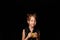 A girl of 6 years, on a black background, with a yellow camera in her hands.Learning photography.