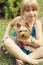 Girl 6 years old on the grass holding Yorkshire Terrier