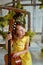 Girl, 6 years old.Her hair is loose. Yellow dress, Mimosa, beautiful interior. Laughing and holding a guitar. Music