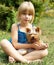 Girl 6 years old sitting on the grass with Yorkshire Terrier