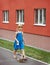 Girl 6 years old walking with a Yorkshire terrier near high-rise building