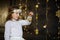 Girl of 8-9 years with delight admires gold Christmas-tree decorations.