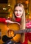 Girl with acoustic guitar in festive environment