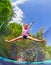 Girl acrobat split jumping on outdoor trampoline