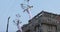 Girl acrobat in white dress in the air above the street in a big chandelier on the rope