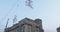 Girl acrobat in white dress in the air above the street in a big chandelier on the rope