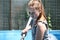 A girl in action, cleaning a swimming pool